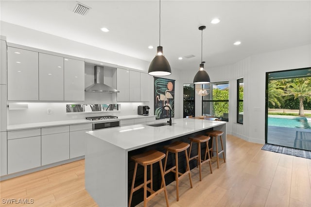 4045 Nova Ln, Naples, FL 34119 - kitchen featuring light wood-style flooring, a sink, wall chimney range hood, and modern cabinets