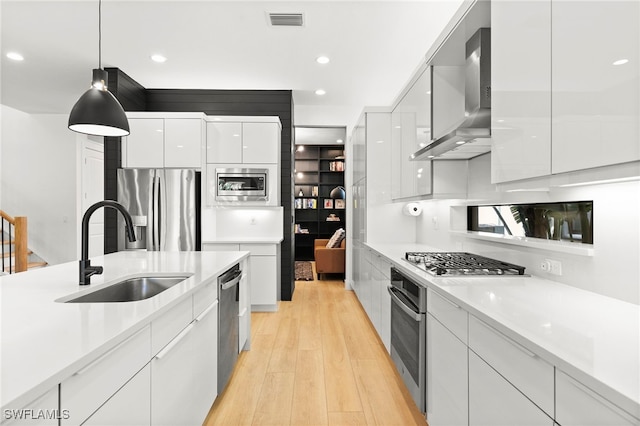 4045 Nova Ln, Naples, FL 34119 - kitchen featuring modern cabinets, wall chimney range hood, white cabinetry, appliances with stainless steel finishes, and a sink