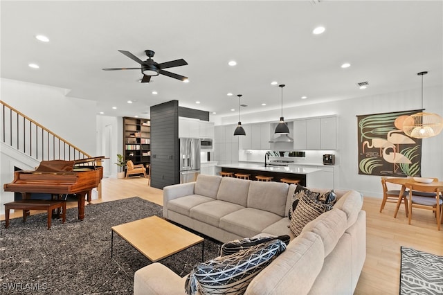 4045 Nova Ln, Naples, FL 34119 - living room with light wood-type flooring, ceiling fan, recessed lighting, and stairway