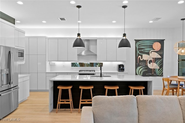 4045 Nova Ln, Naples, FL 34119 - kitchen featuring appliances with stainless steel finishes, wall chimney range hood, modern cabinets, and a kitchen breakfast bar