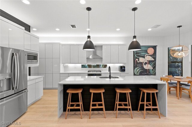 4045 Nova Ln, Naples, FL 34119 - kitchen with visible vents, wall chimney exhaust hood, modern cabinets, a sink, and stainless steel appliances