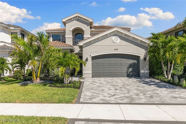 4045 Nova Ln, Naples, FL 34119 - mediterranean / spanish home with stucco siding, decorative driveway, an attached garage, a front yard, and a tiled roof