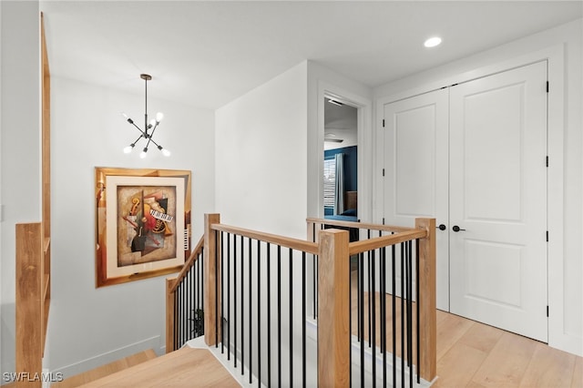 4045 Nova Ln, Naples, FL 34119 - hallway featuring light wood-type flooring, an upstairs landing, a chandelier, and recessed lighting