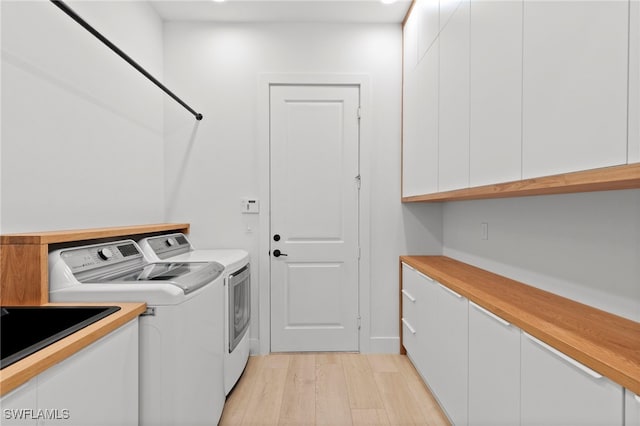 4045 Nova Ln, Naples, FL 34119 - washroom with light wood-type flooring, washing machine and clothes dryer, and cabinet space