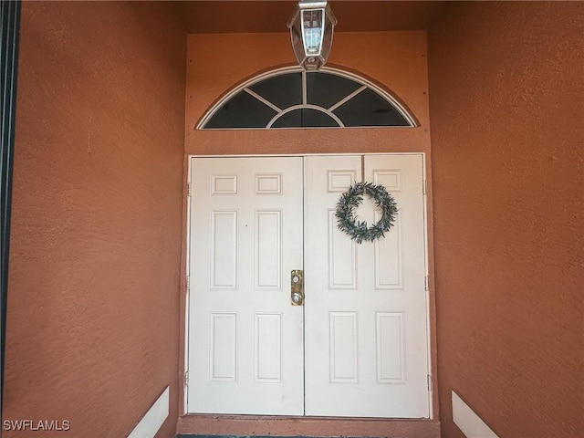 doorway to property featuring stucco siding
