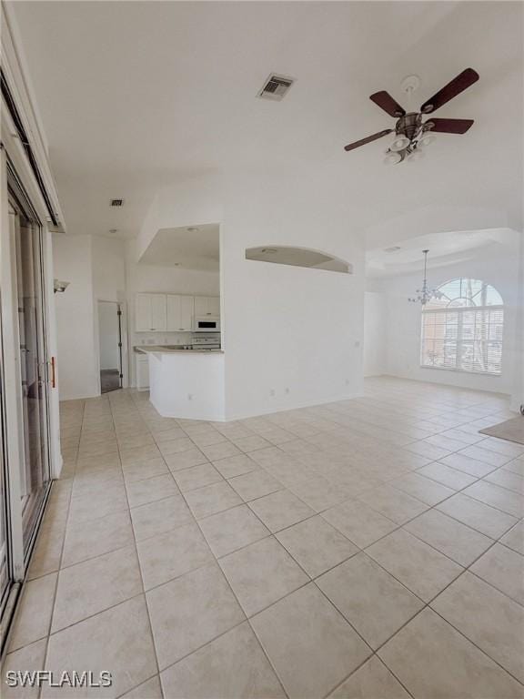 unfurnished living room with visible vents, light tile patterned floors, and ceiling fan with notable chandelier