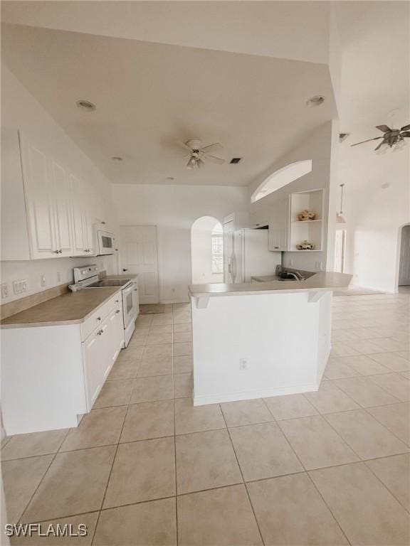 kitchen with light tile patterned floors, ceiling fan, white cabinetry, a peninsula, and white appliances