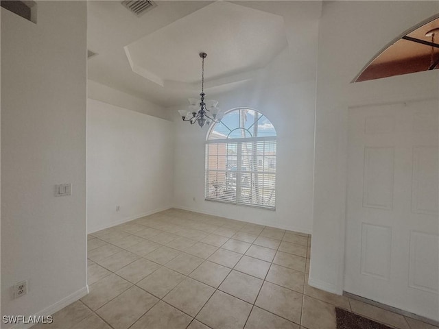 unfurnished dining area featuring an inviting chandelier, light tile patterned floors, a tray ceiling, visible vents, and baseboards