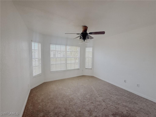 carpeted empty room with baseboards and a ceiling fan