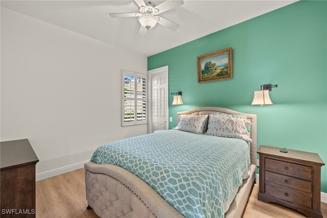 bedroom with wood finished floors, a ceiling fan, and baseboards