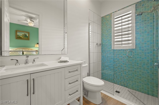 full bathroom featuring a shower stall, a ceiling fan, vanity, and toilet