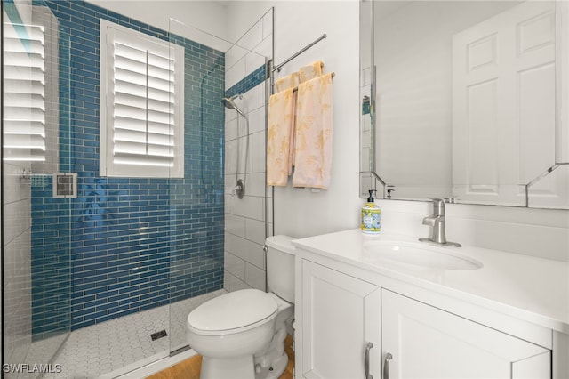 full bath featuring toilet, vanity, and a stall shower