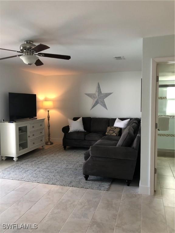 411 SW 34th Ter, Cape Coral, FL 33914 - living area featuring baseboards, a ceiling fan, and light tile patterned floors