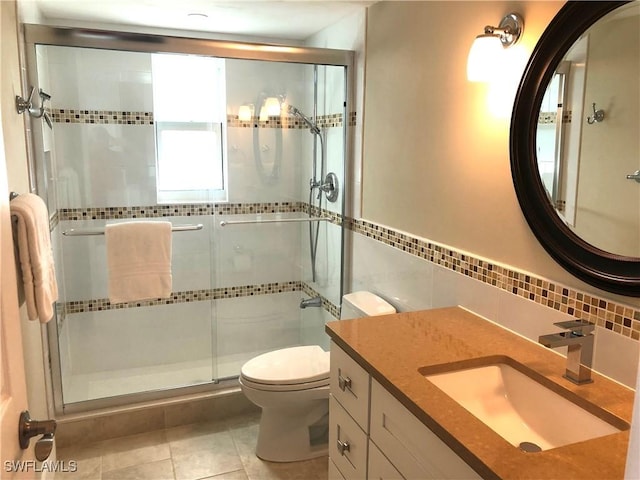 411 SW 34th Ter, Cape Coral, FL 33914 - bathroom featuring toilet, vanity, a shower stall, tile walls, and tile patterned flooring