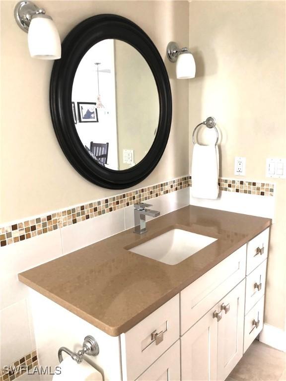 411 SW 34th Ter, Cape Coral, FL 33914 - bathroom featuring vanity and decorative backsplash
