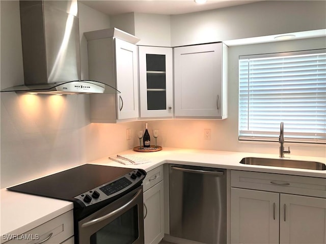 411 SW 34th Ter, Cape Coral, FL 33914 - kitchen with wall chimney exhaust hood, stainless steel appliances, a sink, light countertops, and glass insert cabinets