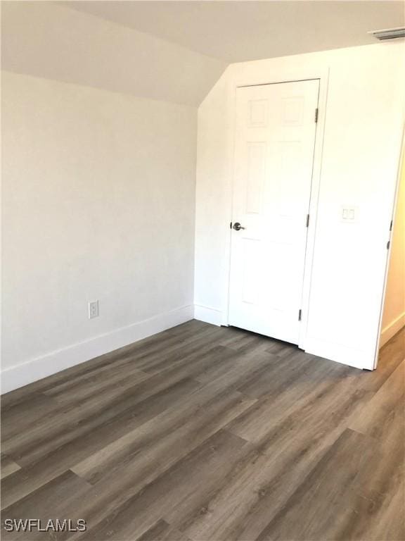 411 SW 34th Ter, Cape Coral, FL 33914 - unfurnished bedroom featuring baseboards, dark wood-style floors, and vaulted ceiling