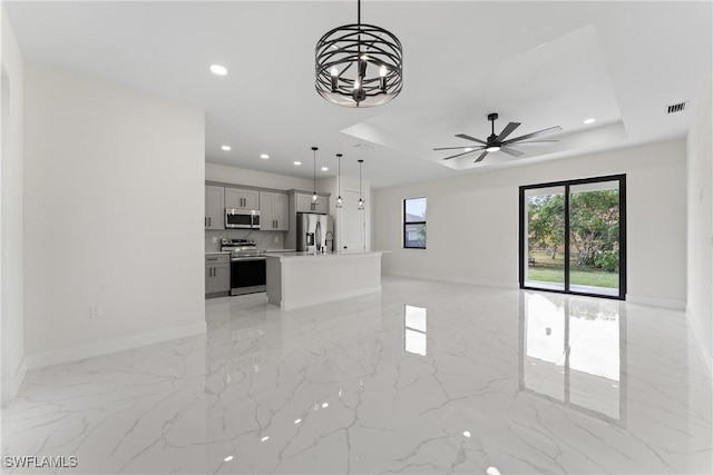 5327 Beauty St, Lehigh Acres, FL 33971 - unfurnished living room featuring recessed lighting, marble finish floor, a tray ceiling, visible vents, and baseboards