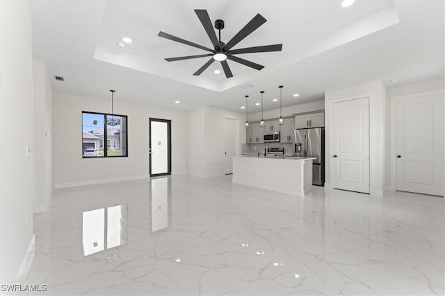 5327 Beauty St, Lehigh Acres, FL 33971 - unfurnished living room featuring a ceiling fan, a tray ceiling, recessed lighting, and marble finish floor