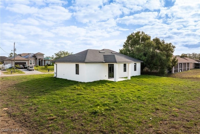 5327 Beauty St, Lehigh Acres, FL 33971 - back of property featuring stucco siding, a residential view, and a yard