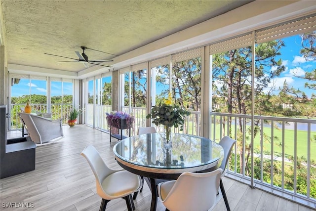 sunroom / solarium with a textured ceiling, a healthy amount of sunlight, and wood finished floors