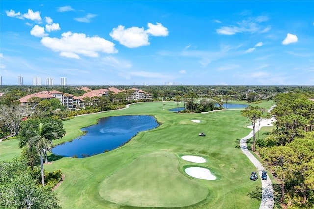 drone / aerial view with golf course view and a water view