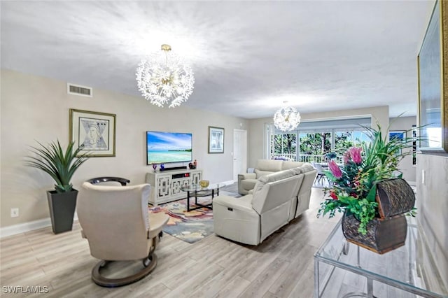 living area featuring visible vents, baseboards, an inviting chandelier, and light wood-style flooring