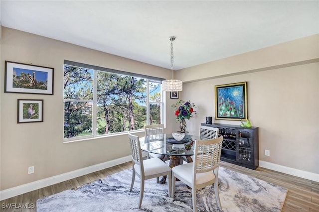 dining room featuring baseboards, an inviting chandelier, and wood finished floors