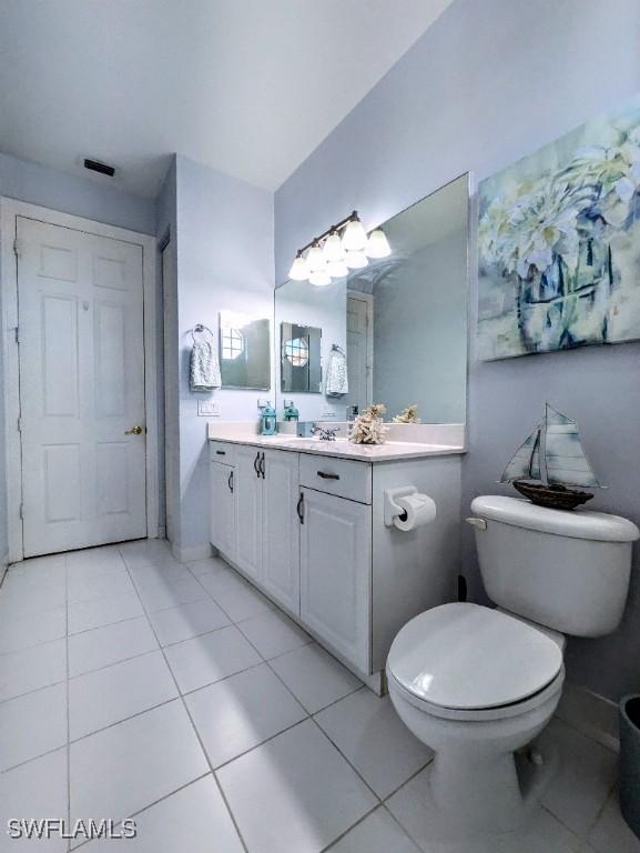 bathroom featuring toilet, visible vents, tile patterned floors, and vanity