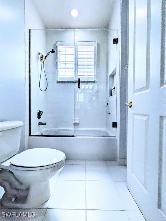 bathroom with toilet, tile patterned floors, and shower / tub combination
