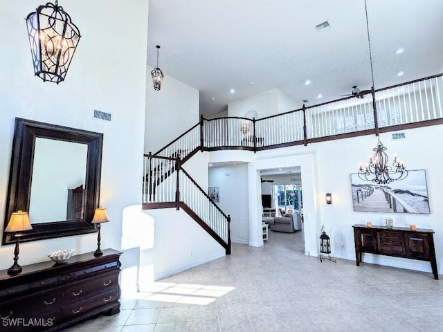 entryway featuring a high ceiling, baseboards, visible vents, and stairs