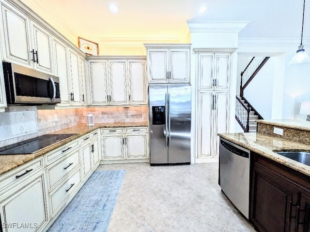 kitchen featuring tasteful backsplash, ornamental molding, appliances with stainless steel finishes, and light stone countertops