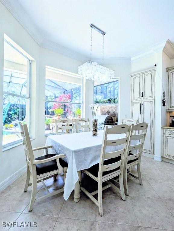 dining space featuring crown molding, light tile patterned floors, a notable chandelier, and baseboards