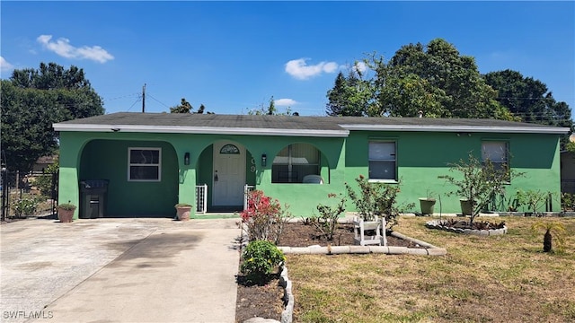 509 W Obispo Ave, Clewiston, FL 33440 - view of front of house with stucco siding, driveway, a front yard, and fence