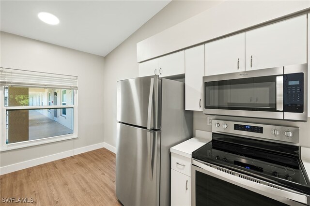 9200 Highland Woods Blvd Unit 1309, Bonita Springs, FL 34135 - kitchen with baseboards, light wood-style flooring, light countertops, white cabinetry, and stainless steel appliances