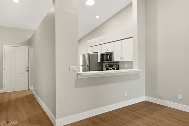 9200 Highland Woods Blvd Unit 1309, Bonita Springs, FL 34135 - kitchen featuring appliances with stainless steel finishes, baseboards, lofted ceiling, and white cabinets