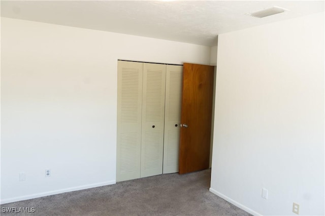 unfurnished bedroom with visible vents, baseboards, carpet floors, and a closet