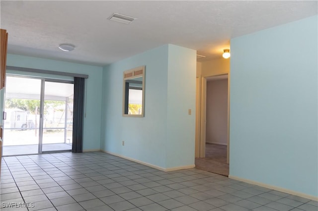 unfurnished room featuring light tile patterned flooring, baseboards, and visible vents