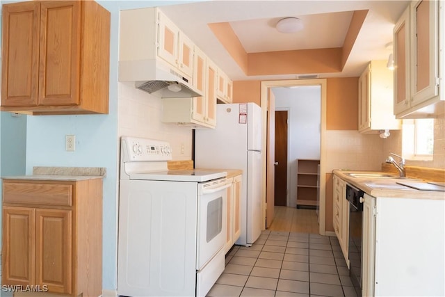 kitchen with a sink, light countertops, decorative backsplash, and white appliances