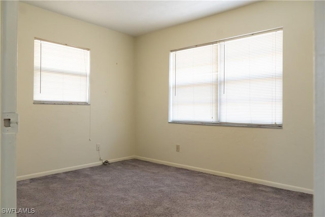 empty room with carpet flooring, baseboards, and plenty of natural light