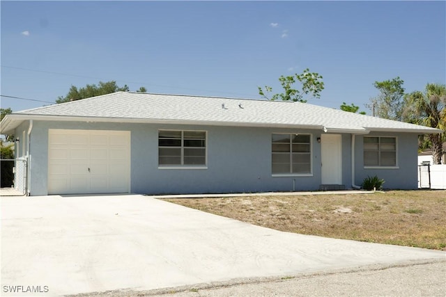 ranch-style house with a garage, stucco siding, and concrete driveway