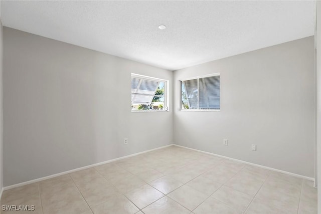 6874 Carmelle Dr, Fort Myers, FL 33919 - empty room with baseboards, light tile patterned floors, and a textured ceiling