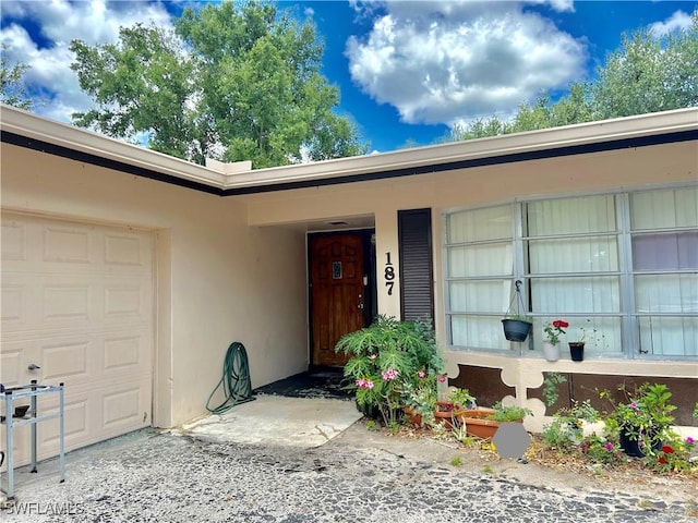 entrance to property with stucco siding and an attached garage
