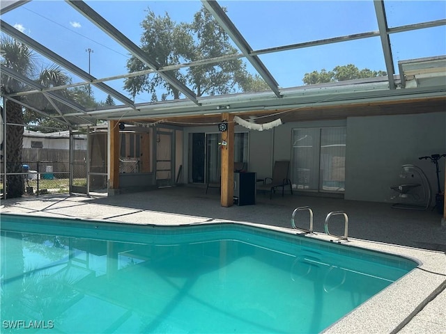 outdoor pool with glass enclosure and a patio area