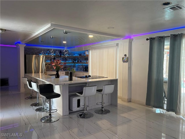 bar with visible vents, a sink, freestanding refrigerator, black electric stovetop, and marble finish floor