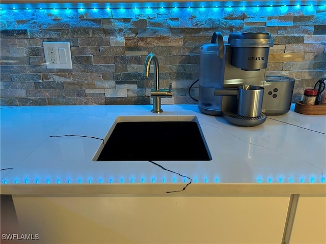 details featuring a sink, light countertops, and tasteful backsplash