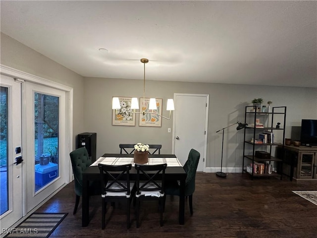 dining space with dark wood-type flooring, baseboards, and an inviting chandelier