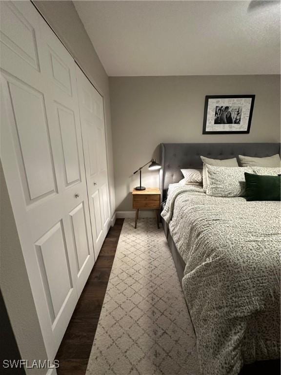 bedroom featuring baseboards and dark wood finished floors