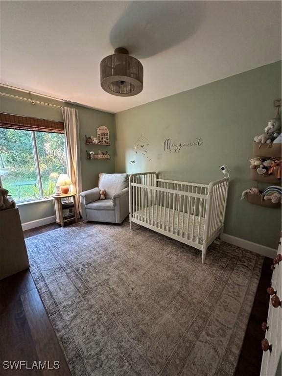 bedroom with baseboards and a nursery area