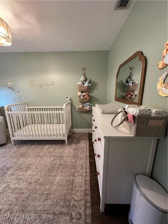 bedroom with visible vents, baseboards, and dark colored carpet